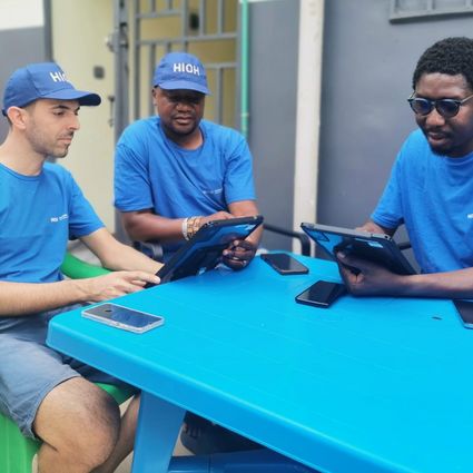 Trois chercheurs sont assis autour d'une table, deux d'entre eux tiennent chacun une tablette dans leurs mains.