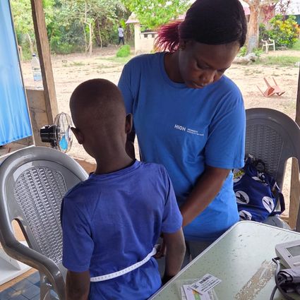 Das medizinische Personal misst das Kind