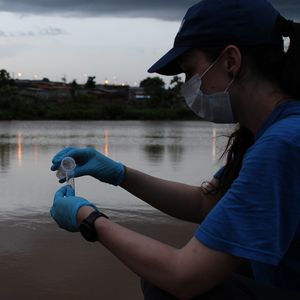 Frau entnimmt Probe vom Fluss