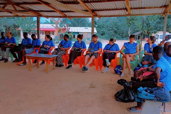 people dressed in blue sitting on chairs