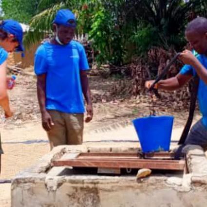 Mann schöpft Wasser aus Brunnen
