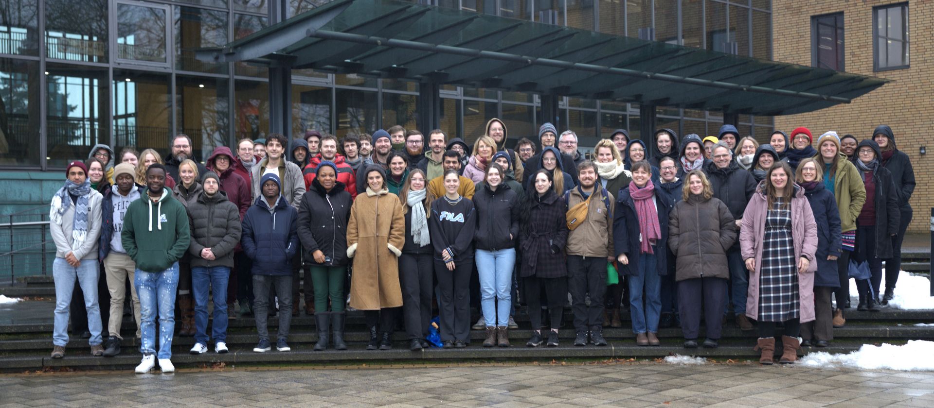 Photo de groupe avec plusieurs personnes alignées sur les marches d'un escalier