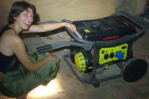 Person kniet neben Generator
