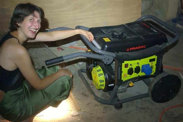 A person is kneeling next to a generator