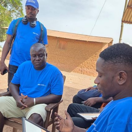 Fünf Personen, im Vordergrund Person mit Tablet